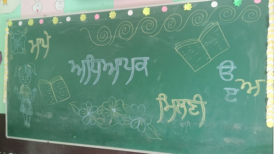 Classroom blackboard decorated with Punjabi chalk lettering and drawings