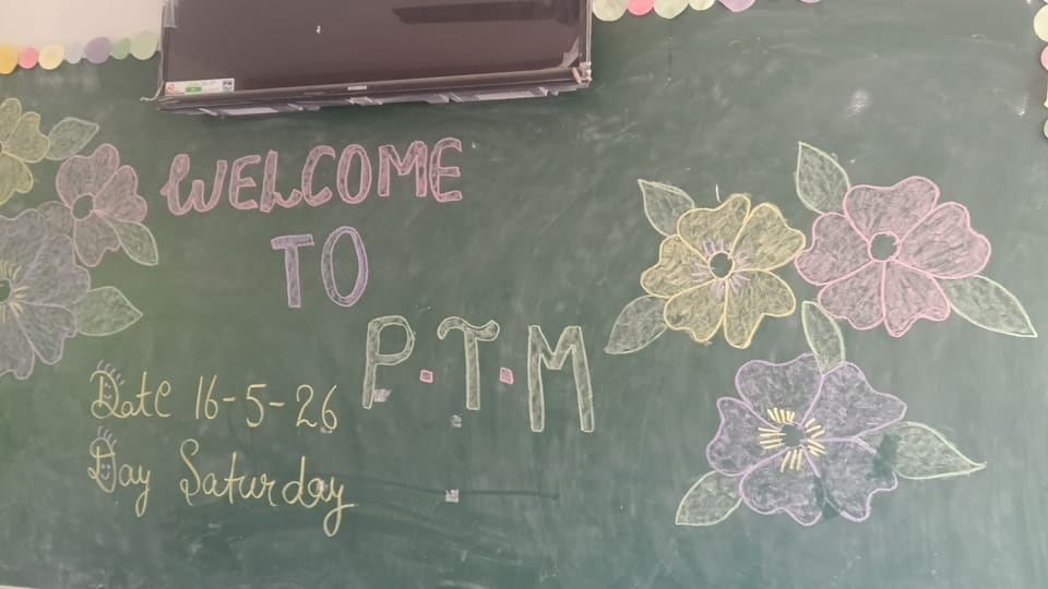 Blackboard reading Welcome to P.T.M with chalk flower decoration