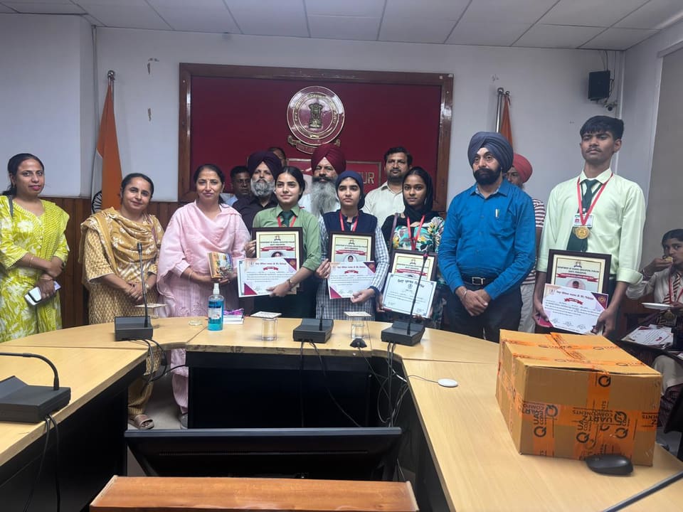 Students holding certificates with teachers at an award ceremony