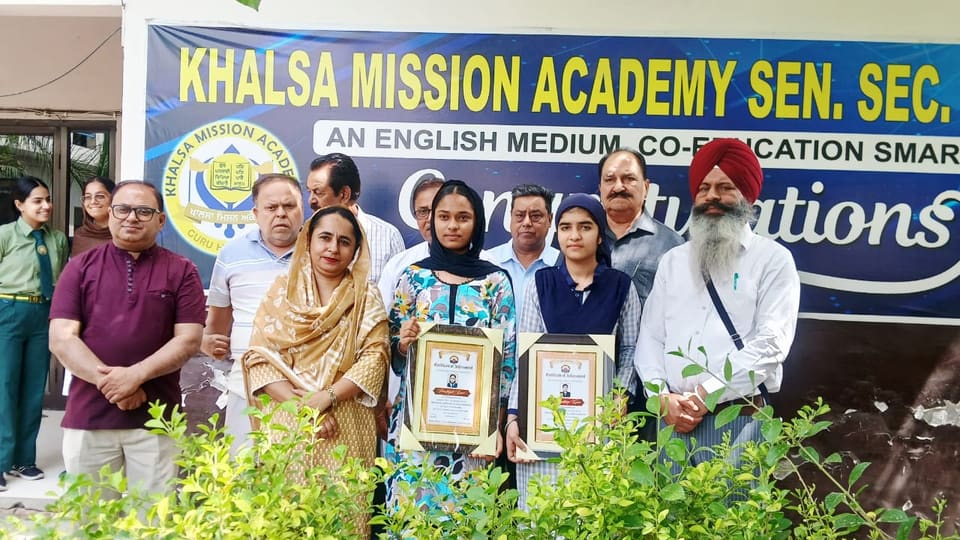Award presentation with framed citations under the school banner