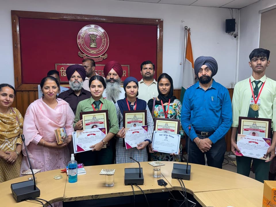 Medal-winning students displaying certificates at the district office