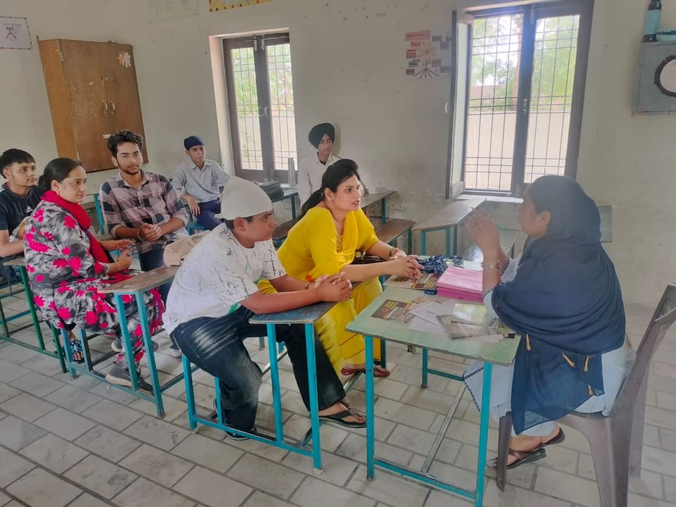 Parents seated at classroom desks meeting the teachers