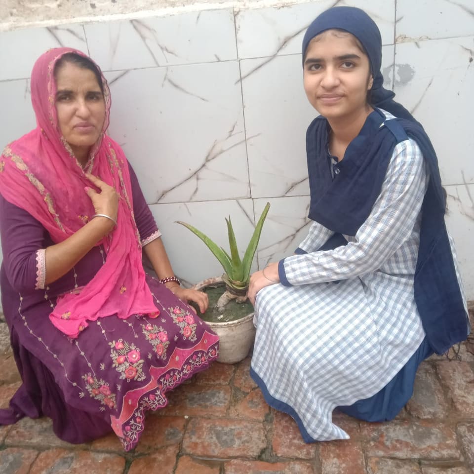A student and a family member with a potted plant