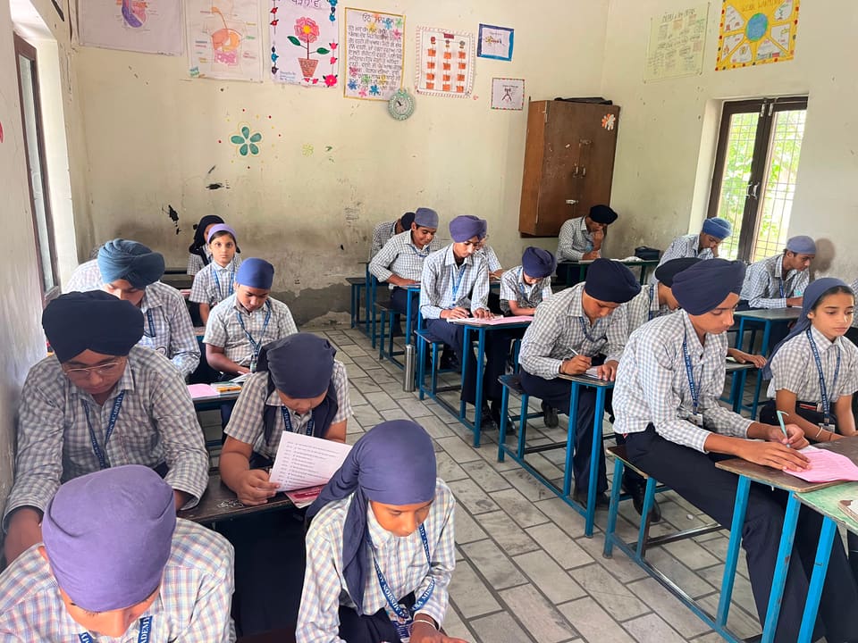 Students writing at their desks in a bright classroom