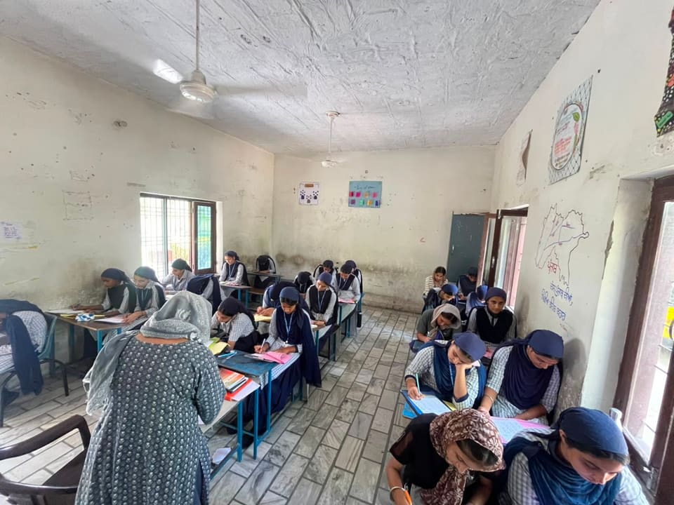 A teacher moving between desks as students complete their work