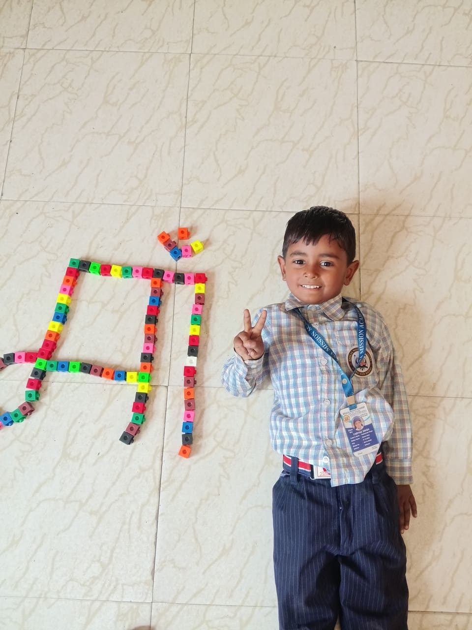 A student presenting a Punjabi letter shaped from craft blocks
