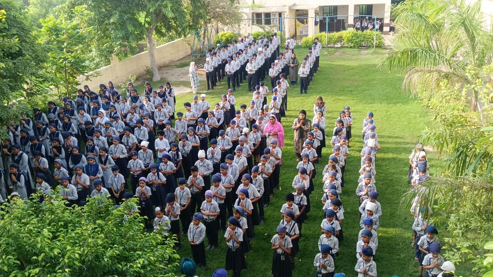 Wide view of the morning assembly with the school block behind