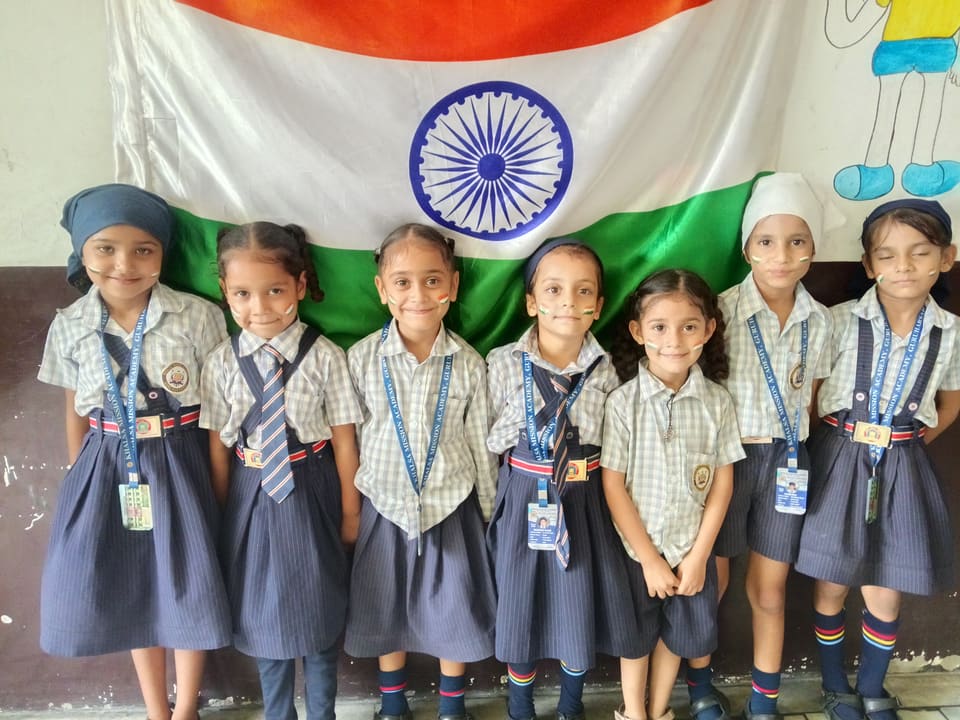 Young students standing together in front of the Indian flag