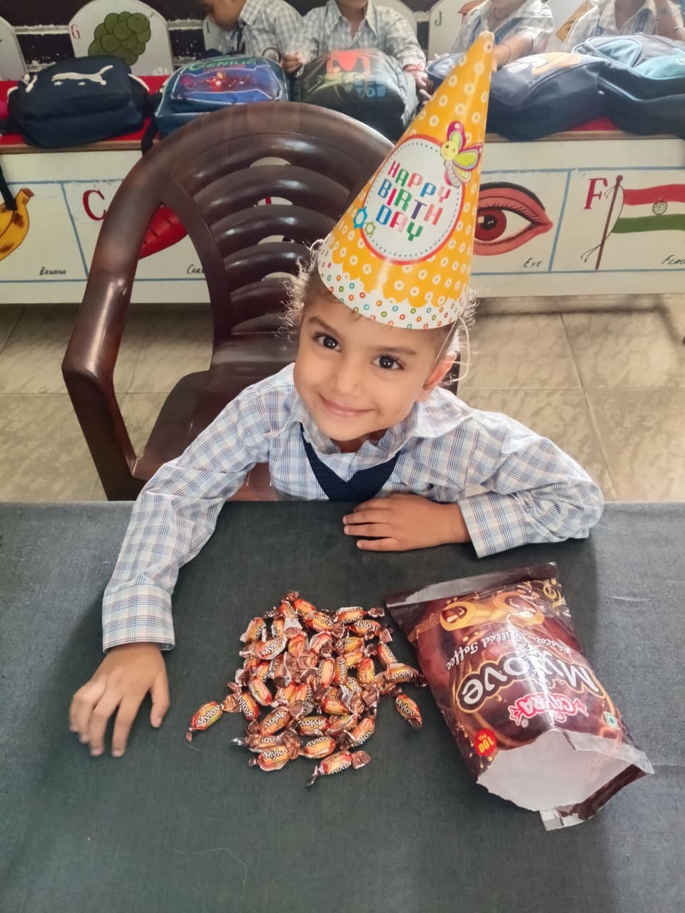 A young student in a party hat celebrating a birthday at school