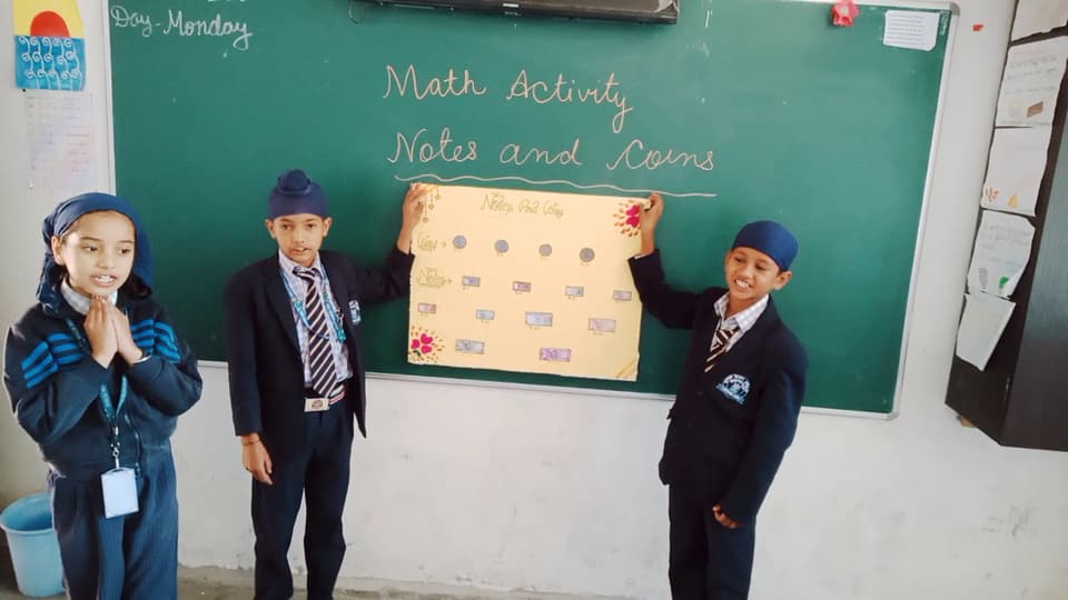Students explaining their maths project to the class
