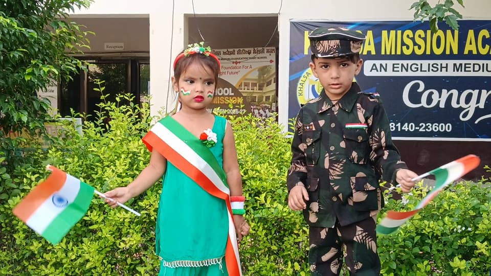 Two students in tricolour and army fancy dress holding national flags