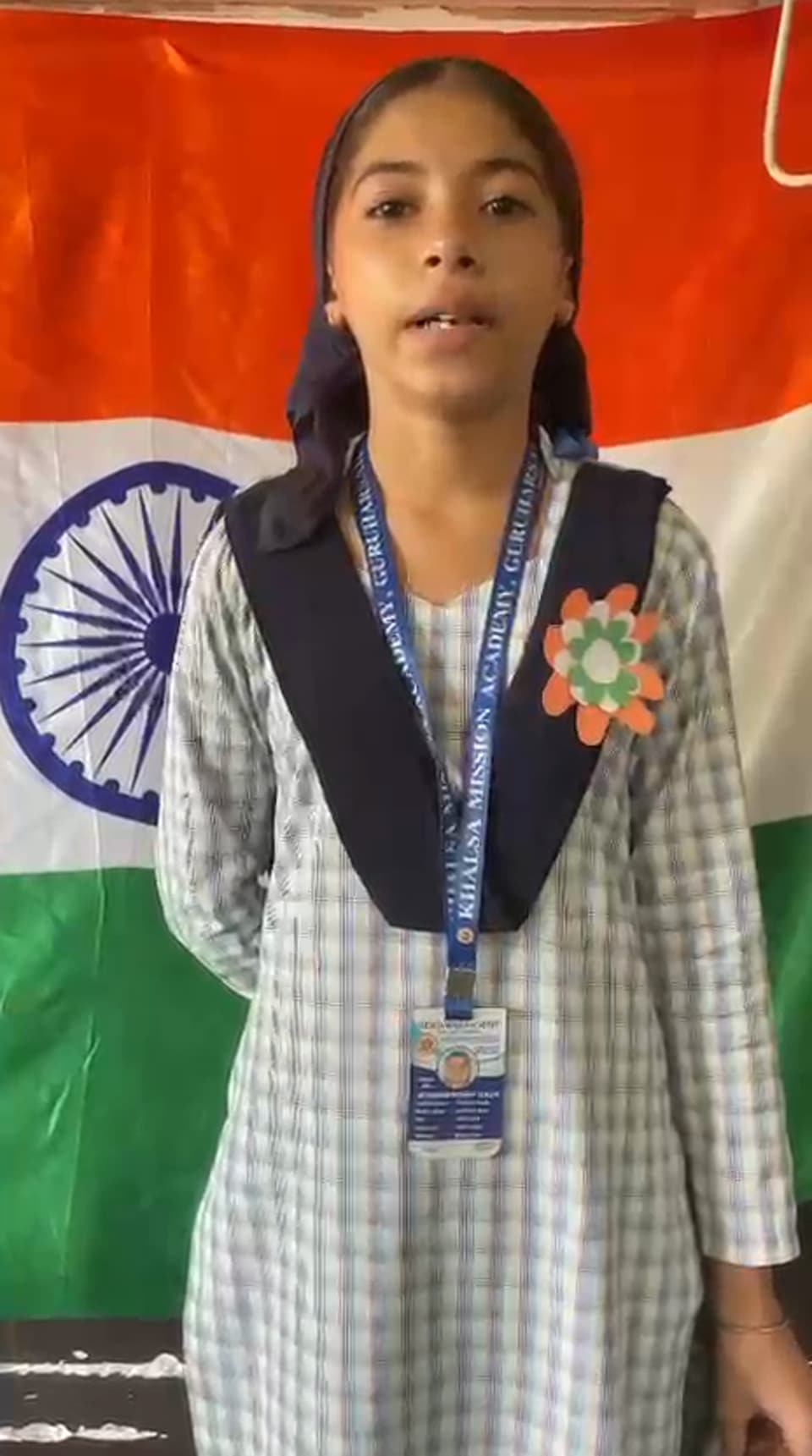 A student delivering a speech in front of the national flag
