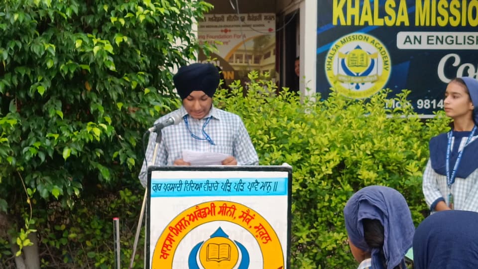 A student reading the thought of the day at the assembly lectern