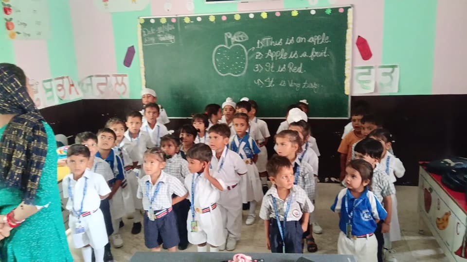 Young students with their teacher at the start of the day