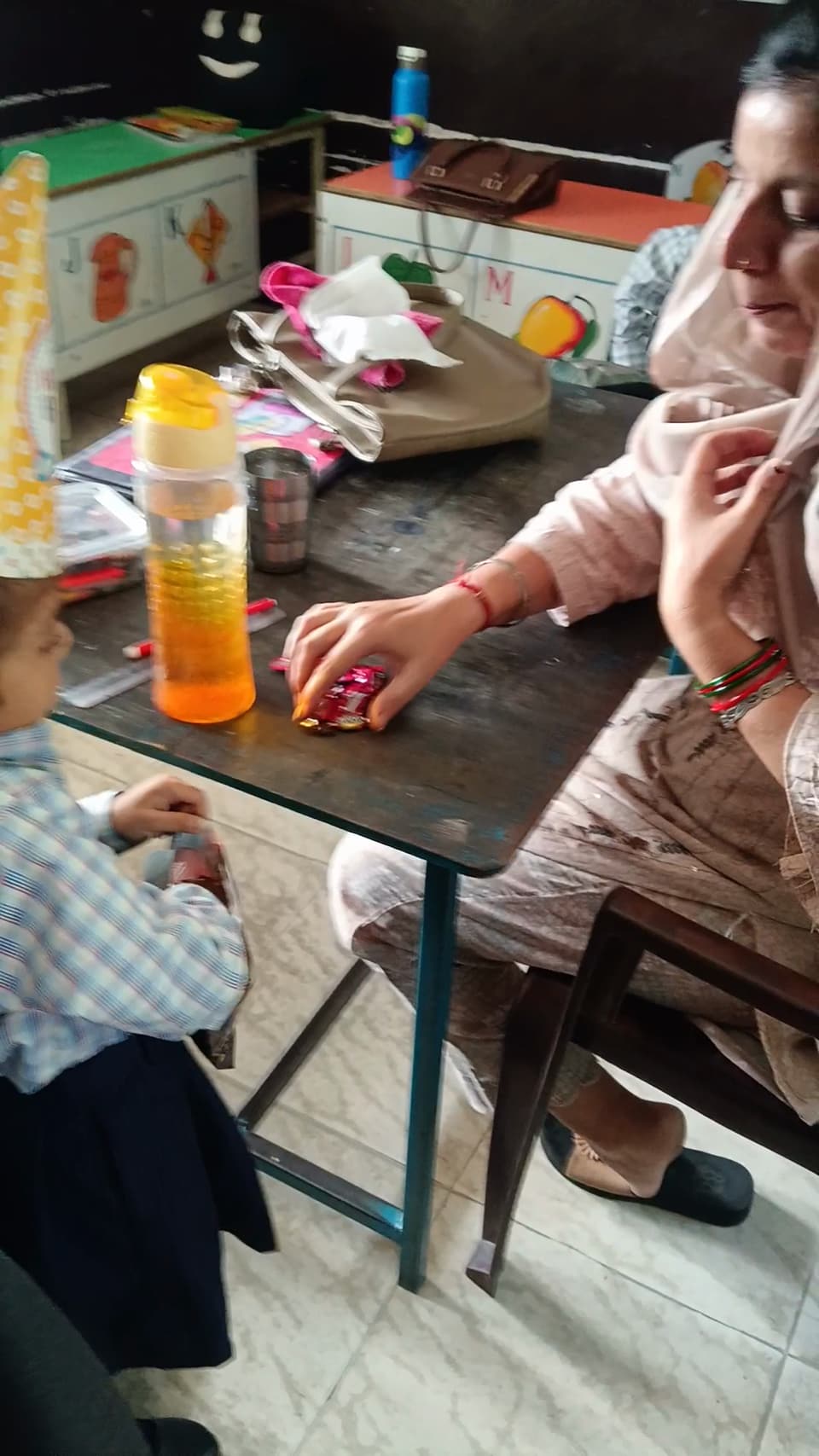 A teacher working alongside a young student at a desk