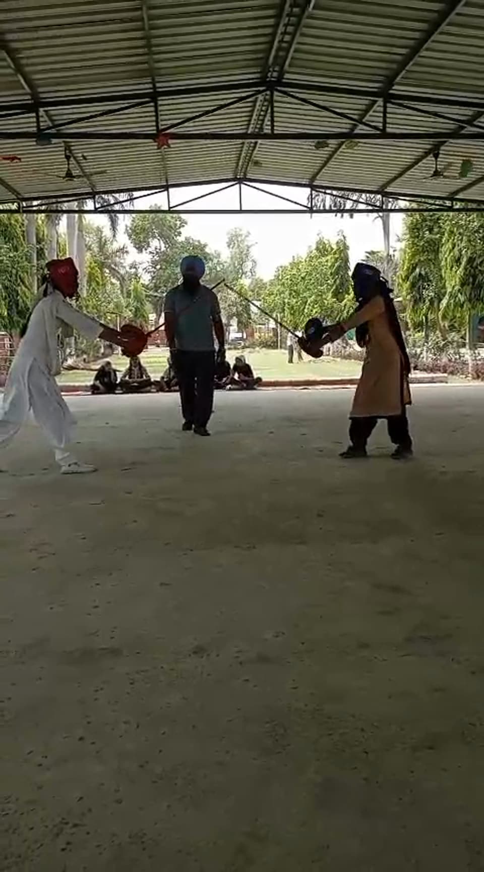 Students performing Gatka on a mat under the school canopy