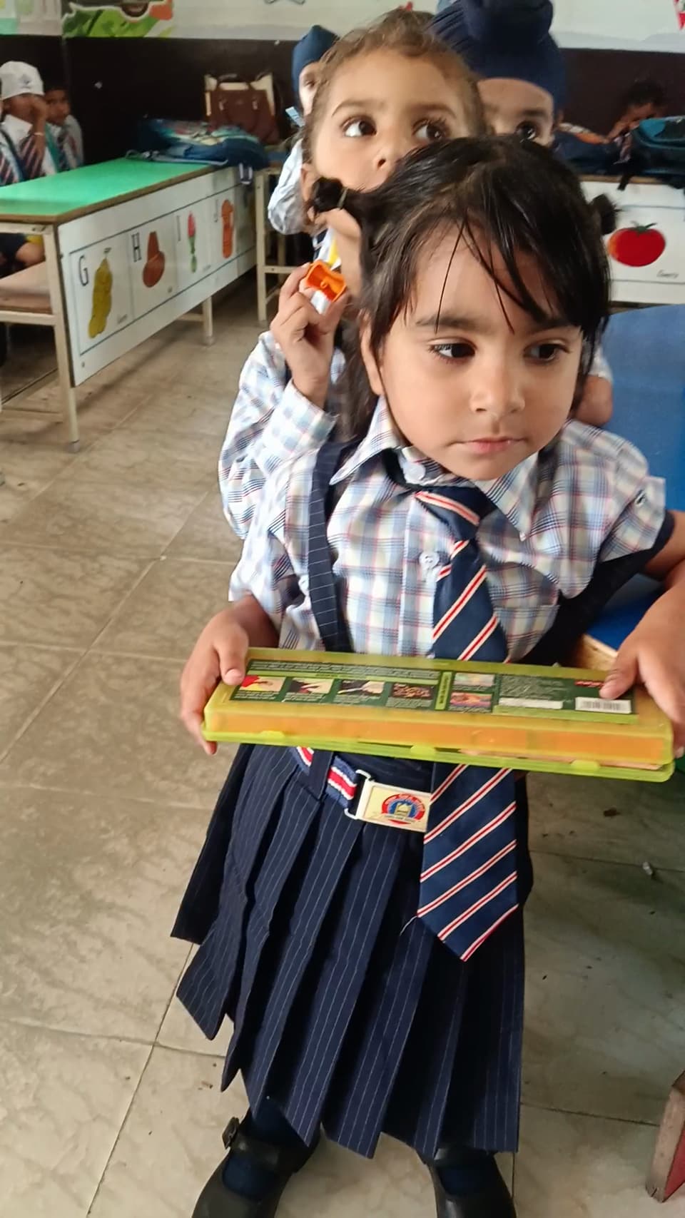 A young student carrying an abacus in class