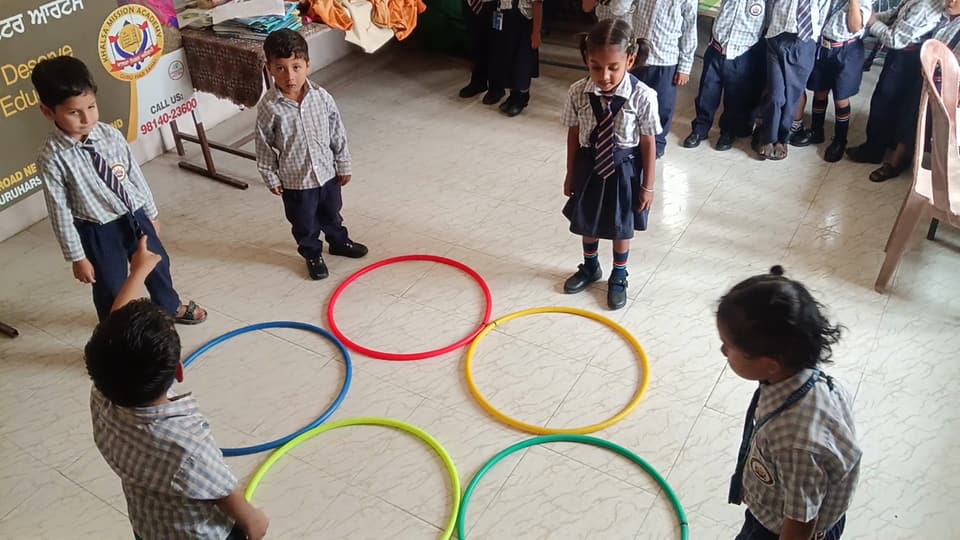 Young students playing a ring game in the school hall